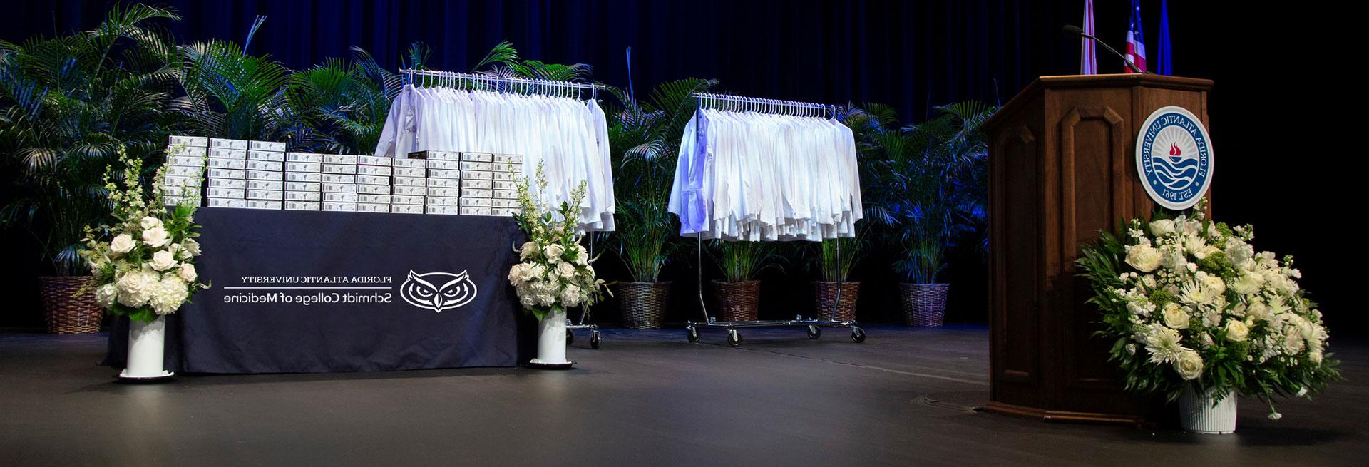 FAU White Coat Ceremony podium with rack of White Coats